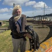 Jeff Pennington and his nine-year-old dog Amelia pictured outside of the Berney Arms by Breydon Water