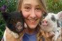 Megan Clarke holding up her pets pigs Tammy and Ruby