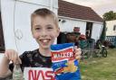Theo Yeldham, 9, with a Fanta bottle dating from the 1960s and a Walkers crisp packet from 1997 which he found on the beach at Hemsby.